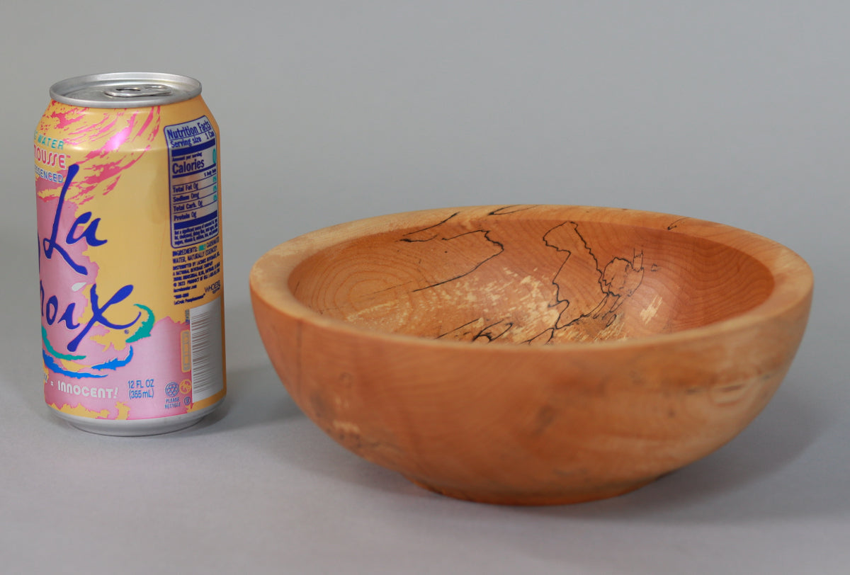 Spalted maple bowl next to beverage can for scale