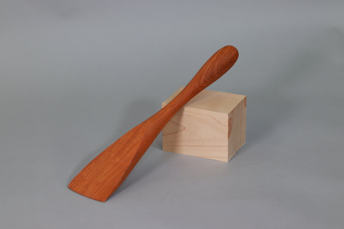 Wooden spatula on a wooden block against a gray background