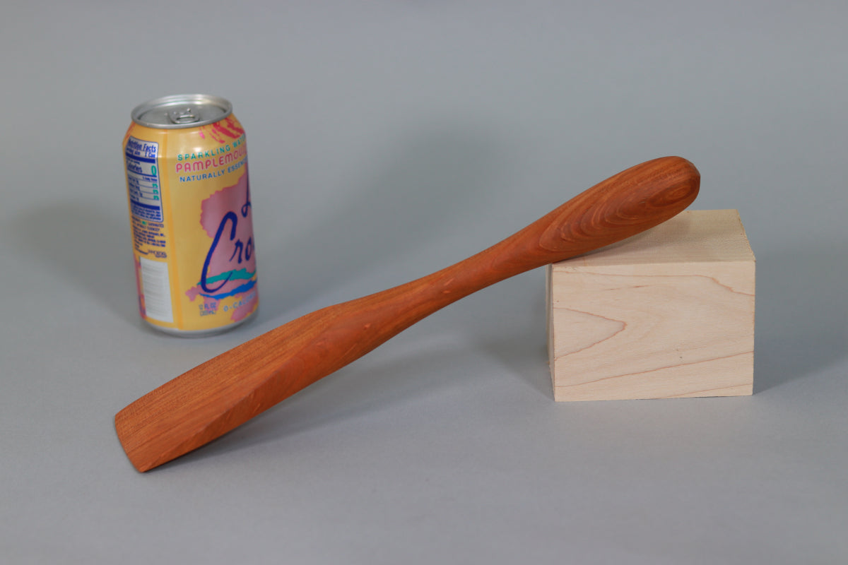 Cherry paddle handmade of urban salvaged wood next to mineral water can