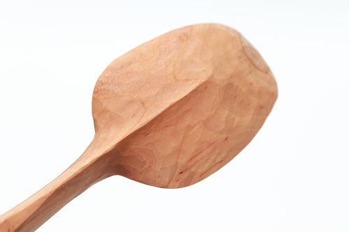 Wooden spoon, seen from the bottom, on a white background. The centerline of the handle is carved to a thin, graceful keel, which extends 2/3 of the way to the front of the spoon's bowl. The hawthorn wood is the color of caramel.