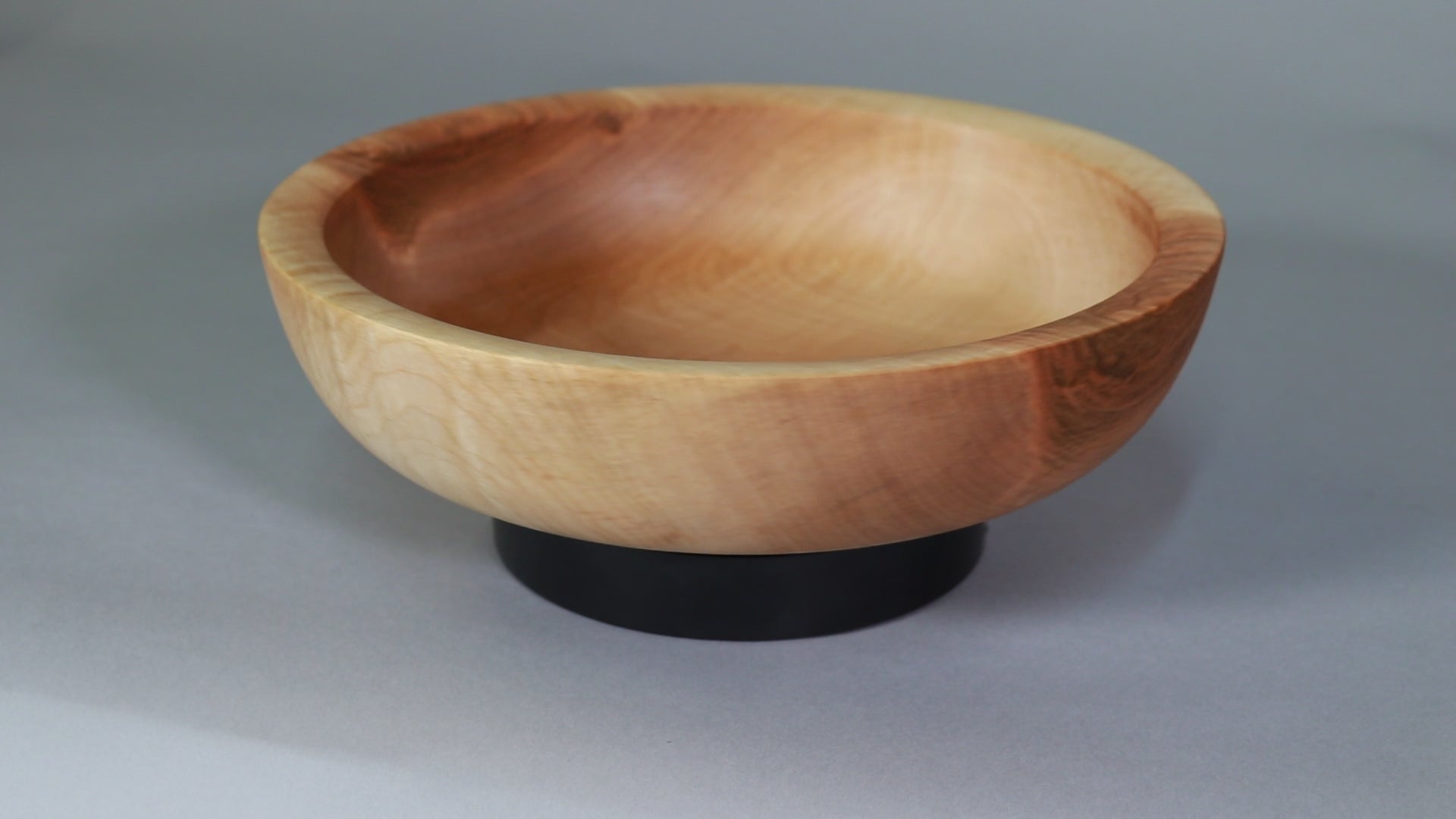 short video of curly maple bowl rotating on black turntable