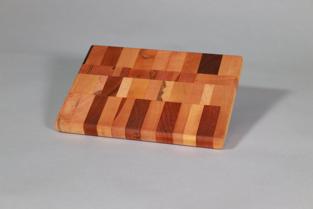 Wooden cutting board with a multicolored pattern on a gray background